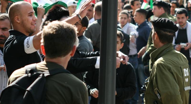 Ein Ordner der Al-Quds-Demonstration „gestikuliert“ in Richtung der Teilnehmer der Gegenkundgebung, während die Berliner Polizei wegschaut © Holger Raak/haOlam.de
